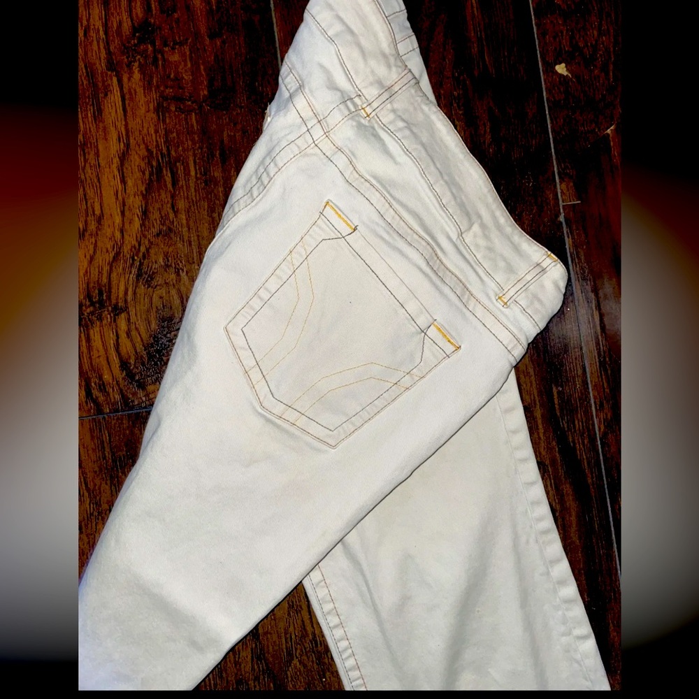 White flare-out jeans with orange stitching